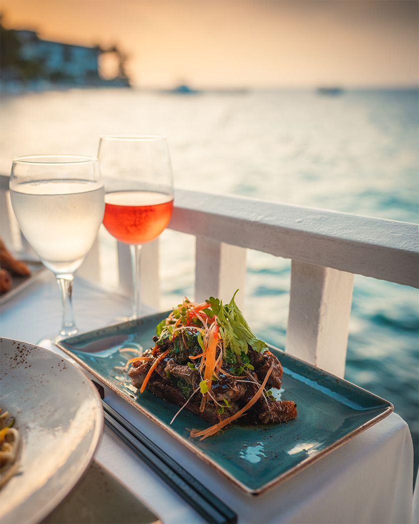 Dinner and a glass of rosé by the sea at sunset