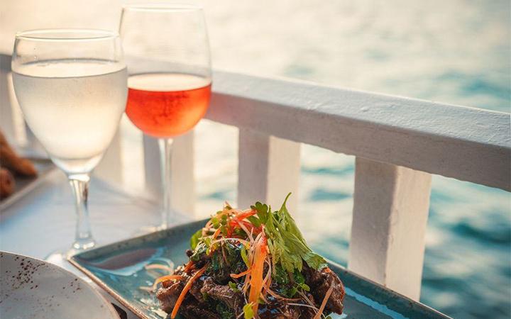 Dinner and a glass of rosé by the water at sunset