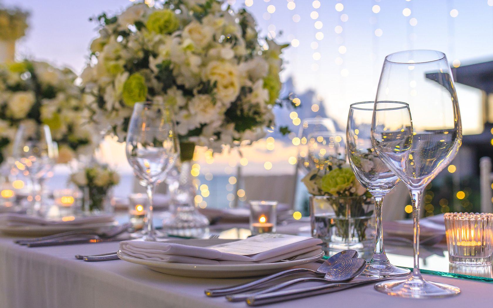 Reception table dressed with white flowers and candles