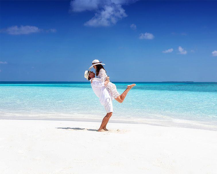 A bride and groom on a white sand beach